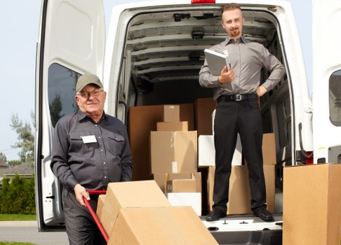 Van crew loading items safely with a trolley and protective blankets